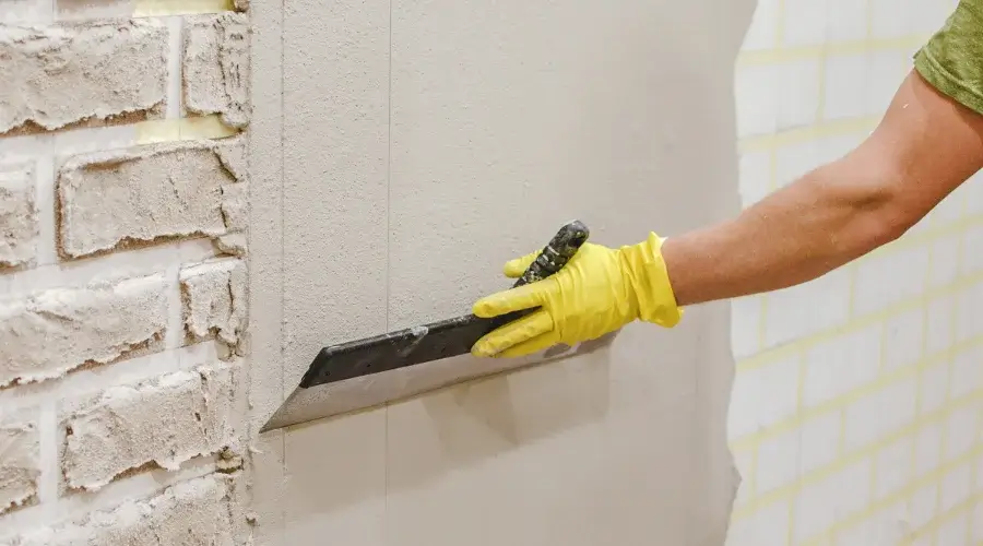 person applying cement on wall
